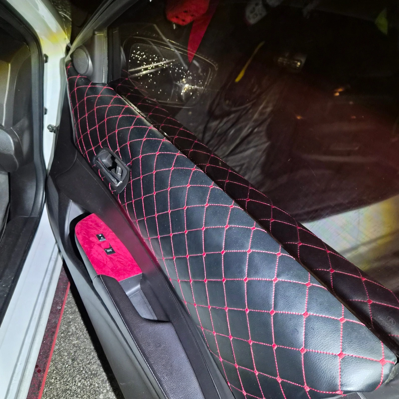 Cleaned Acura door panel with black diamond upholstery and red stitching
