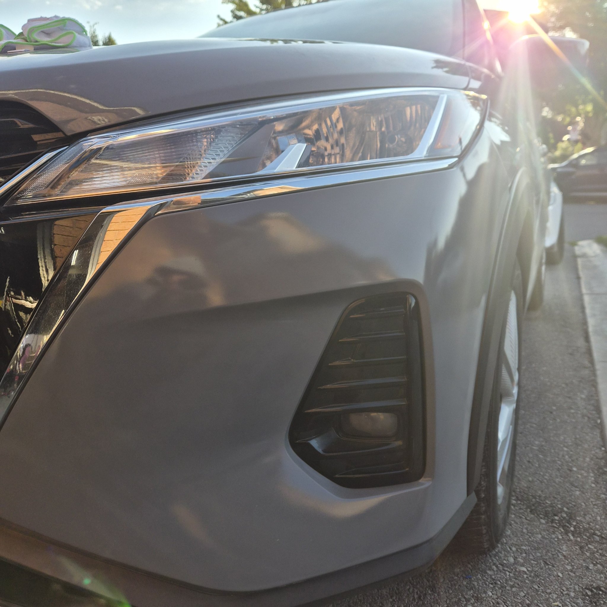 Finished glossy grey Nissan Kicks bumper beside the headlight