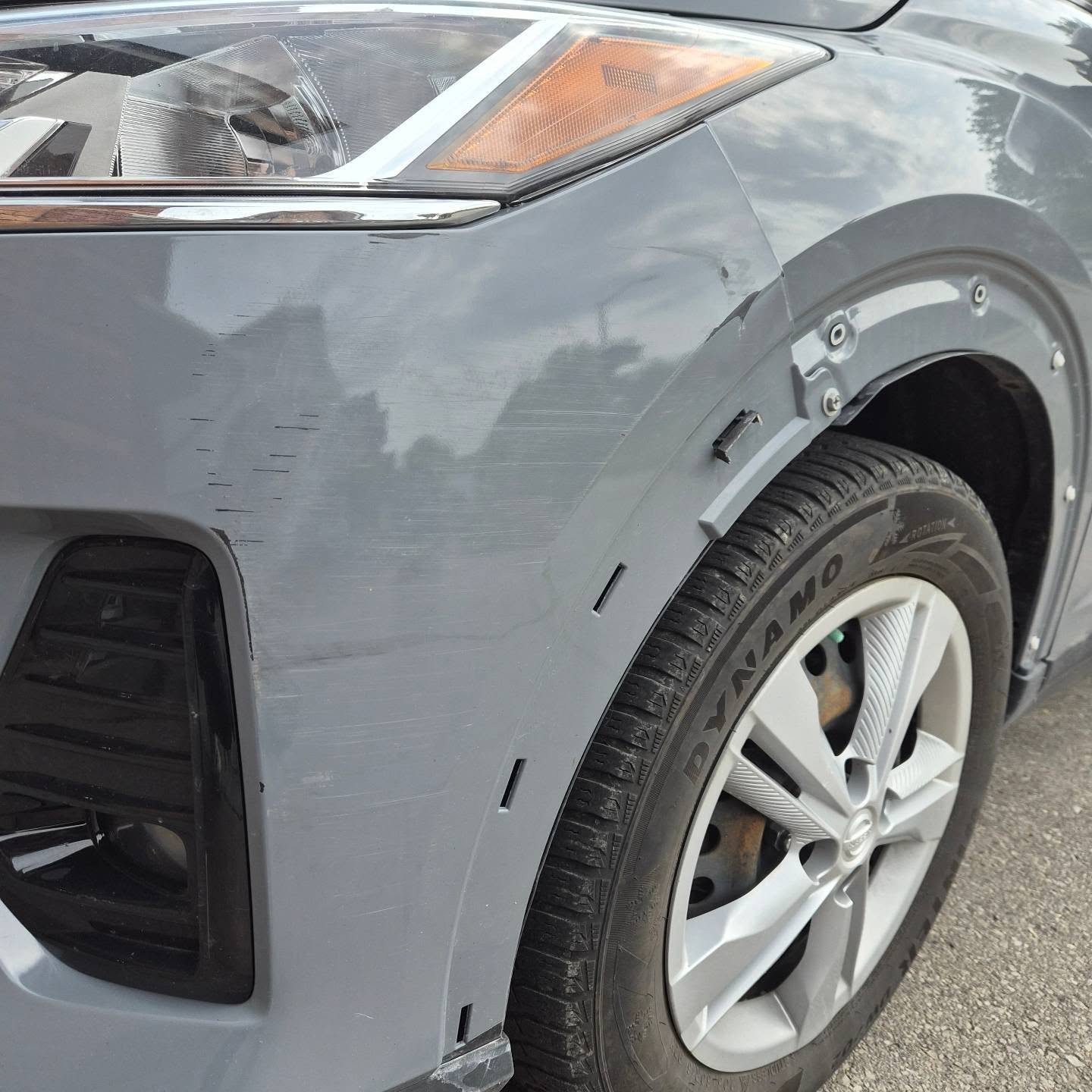 Scratched grey front fender and partially removed fender flare