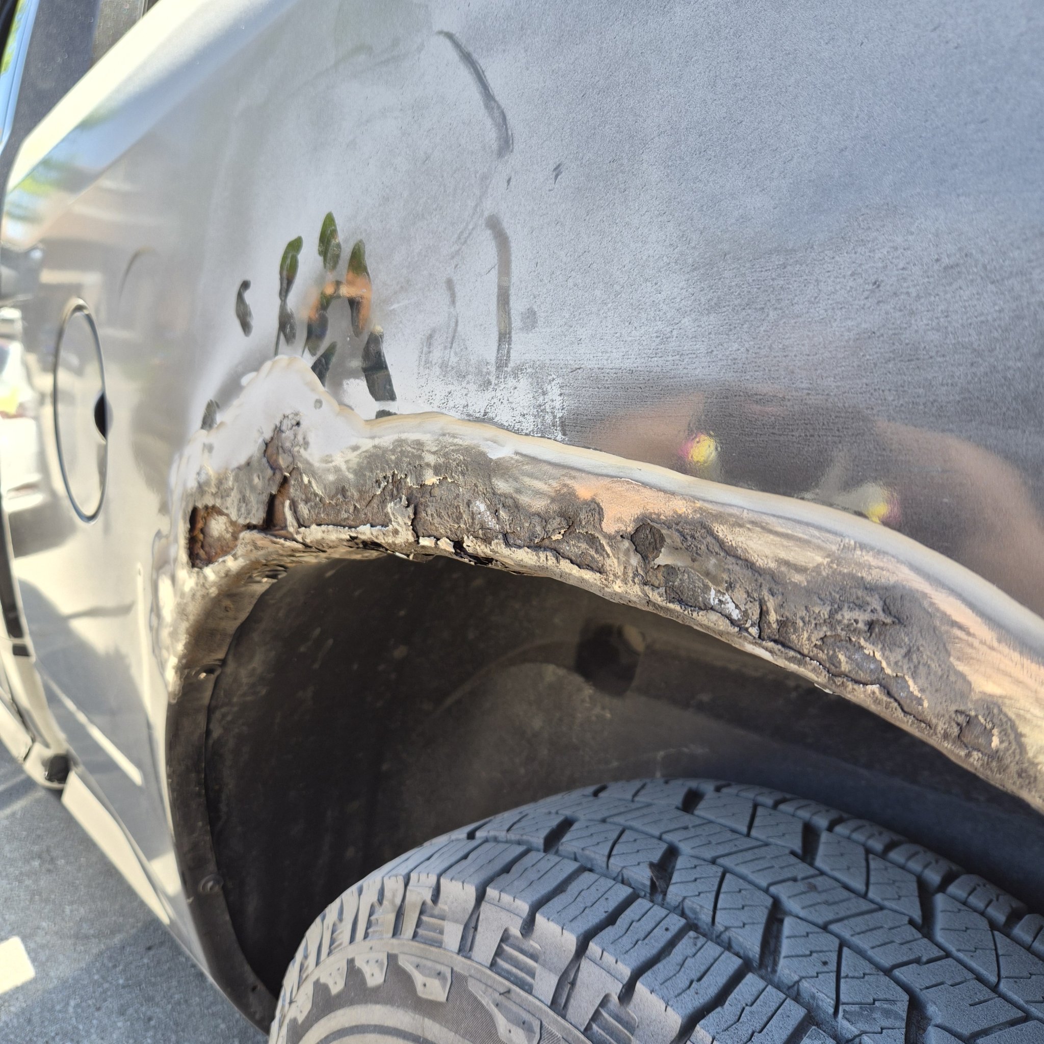 Heavy rust perforation around the black Ram 1500 rear wheel arch