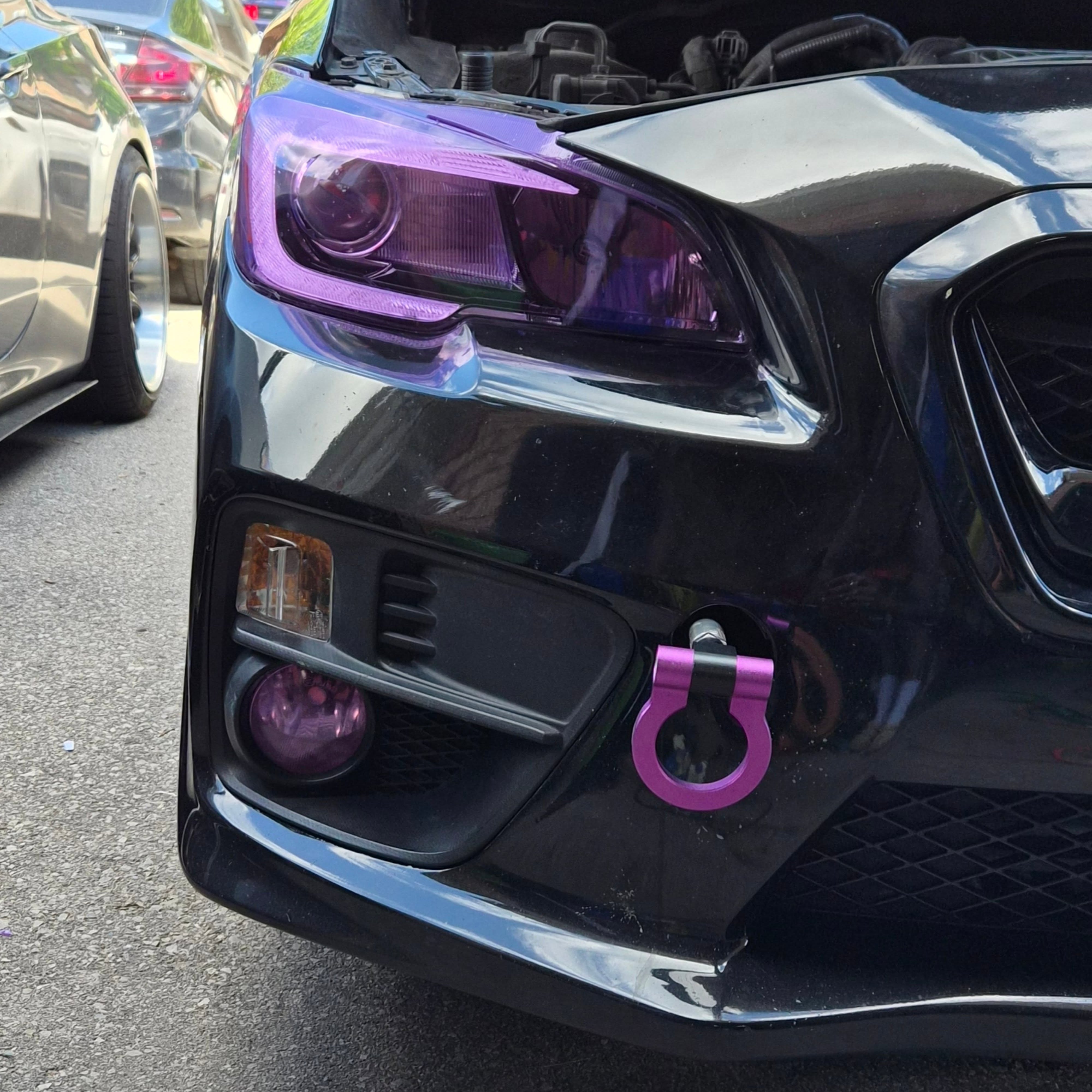 Black Subaru WRX with purple headlight tint, fog lamp and tow hook details